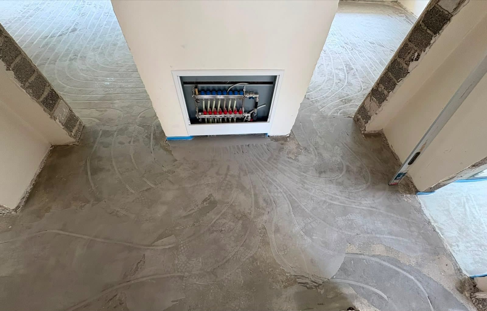 Verteiler in der Wand mit verlegten Heizkreisen